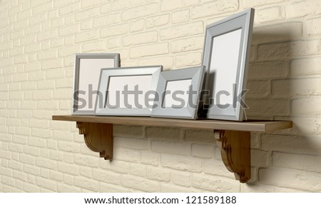 A perspective view of a regular wooden shelf displaying 4 blank metal picture frames on a yellow brick wall