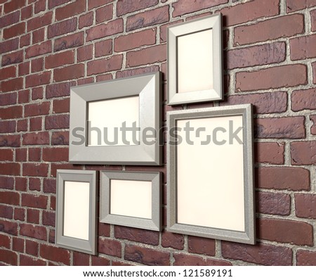 A perspective view of an arrangement of five blank metal picture frames hanging on a red clay brick  brick wall