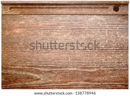 A direct top view of a vintage school desk with a hinged lid and a ink well hole on an isolated background