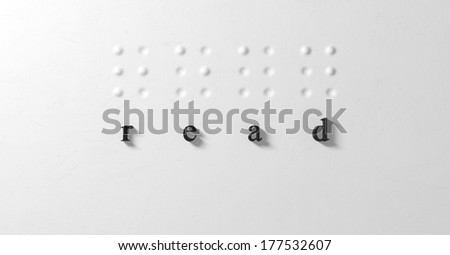 A closeup concept of a set of four isolated braille letters spelling out the word read and extruded regular black letters corresponding on a textured white paper