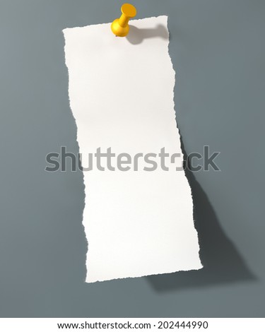A white torn page peeling upwards attached to an isolated grey wall background by a yellow push pin