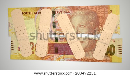 A concept picture of a regular South African two hundred rand note torn in two length ways and held together by medical plasters on an isolated background
