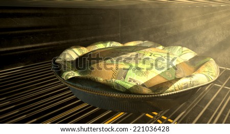 A closeup concept of a money pie made with Australian Dollar bank notes baking in a heated oven