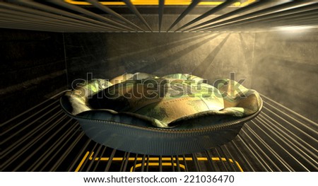 A closeup concept of a money pie made with Australian Dollar bank notes baking in a heated oven