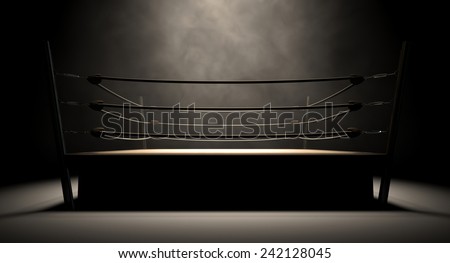 An old vintage boxing ring surrounded by ropes spotlit in the middle on an isolated dark background