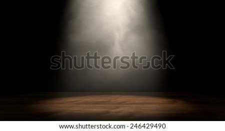 An stage lit by a single spotlight on a dark background