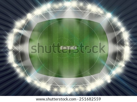 A cricket stadium with a pitch on a marked green grass field in the night time illuminated by an array of spotlights