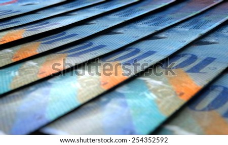 A 3D rendering of a macro close-up view showing the detail of swiss franc banknotes laid out and overlapping in a staggered row
