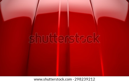An abstract section of the contours of a cherry red automobile bonnet with dramatic lighting on a dark studio background