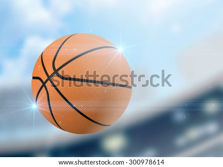A regular basketball flying through the air on a stadium background during the daytime