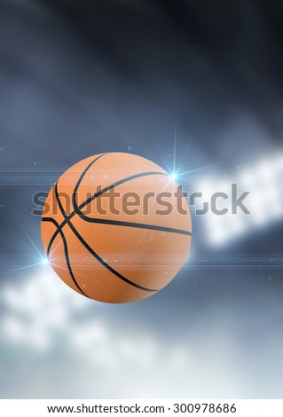 A regular basketball flying through the air on an indoor stadium background during the night