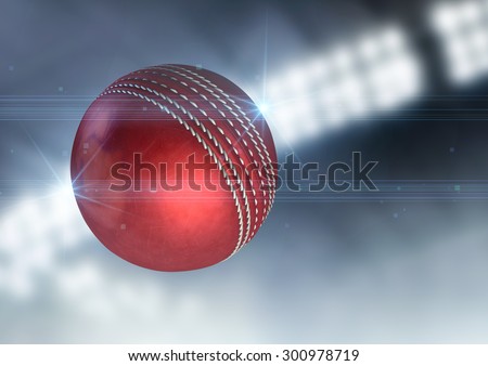 A regular red cricket ball flying through the air on an indoor stadium background during the night