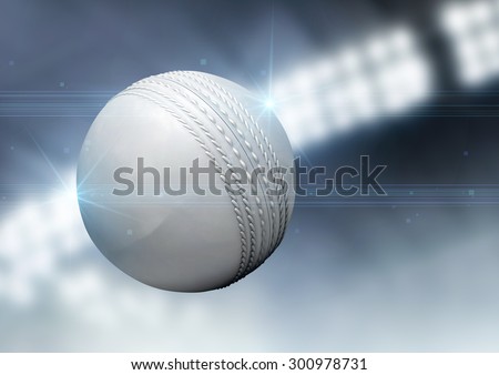 A regular white cricket ball flying through the air on an indoor stadium background during the night