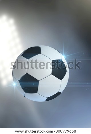 A regular soccer ball flying through the air on an a outdoor stadium background during the night