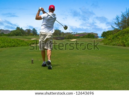 Guy hitting a golf ball on a golf course in Hawaii.