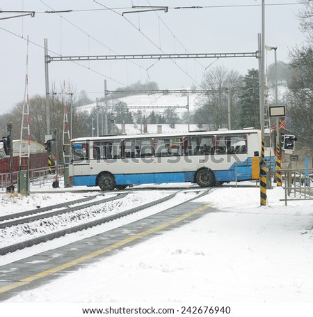 A bus on a railway crossing during  a snow storm