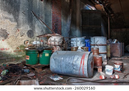 Group of old, rusty barrels with toxic chemical  waste. Photo was taken on place, where textile factory was wrong  demolished.