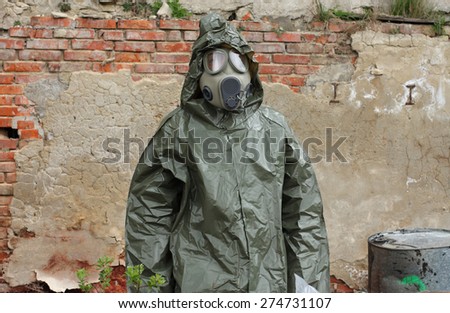 Man with gas mask and green military clothes  explores  small plant  after chemical disaster.