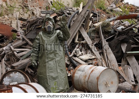 Man with gas mask and green military clothes  explores  after chemical disaster.