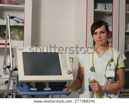 Portrait female nurse in ICU in the green uniform with ventilator machine