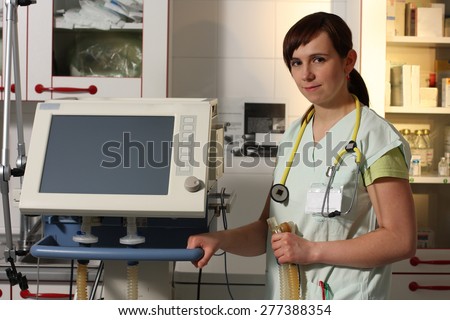 Portrait female nurse in ICU in the green uniform with ventilator machine