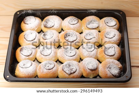 cottage cheese cakes  with jam on baking tray on  wooden table