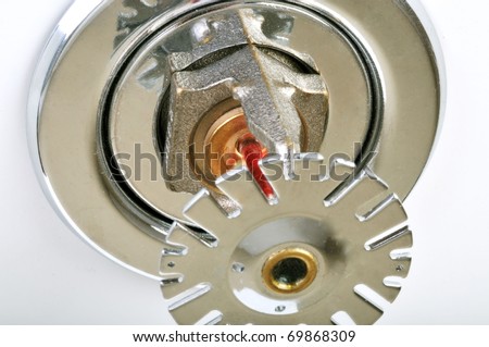 Close up image of fire sprinkler on white. Fire sprinklers are part of an integrated water piping system designed for life and fire safety.