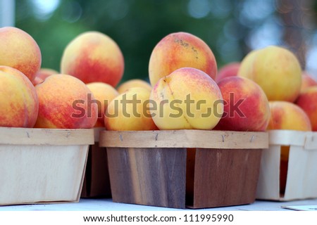 fresh organic peach fruit in wooden basket in market