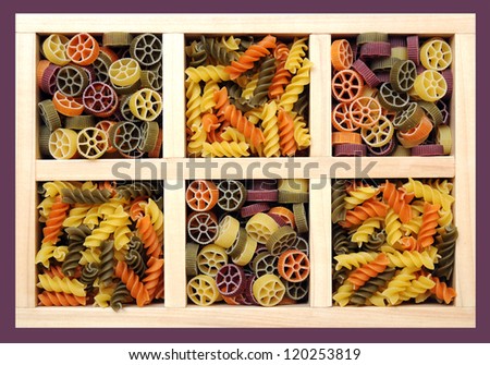 colorful rotini and rotelle pasta in wooden box