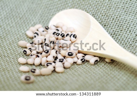 black eyes bean and wooden spoon on green burlap