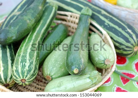 zucchini in bamboo basket at market place under sunshine