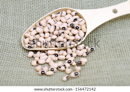 a pile of black eyes beans in scoop on burlap