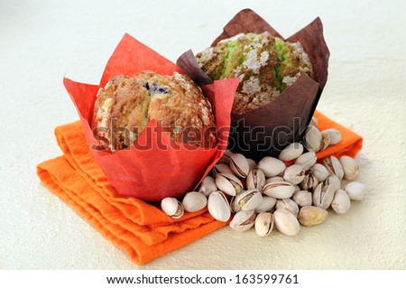 two muffins and pistachio on napkin