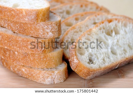 sliced Ciabatta flat bread on wooden cutting board