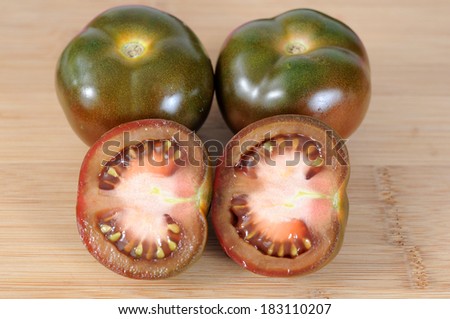 chopped and whole brown tomatoes on cutting board