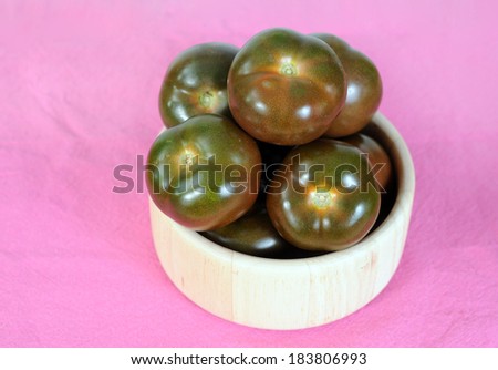 brown tomato with wooden bowl on the table