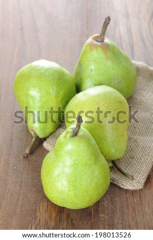 four fresh green pear on the rustic table