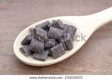 chocolate chips chunks in wooden spoon on the table