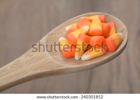 orange teeth candies in wooden spoon on table