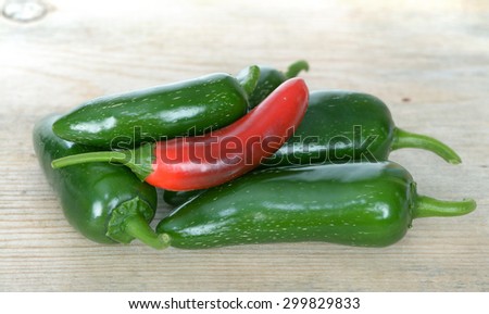 two red and green jalapeno peppers on wooden table