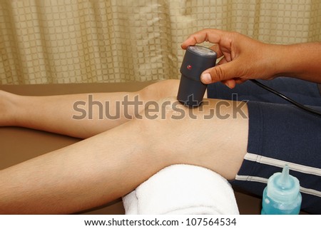 woman in knee trauma  getting physical therapy,physical therapist helping woman with ultrasound therapy for release pain