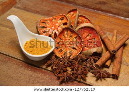 Spices asian, Dry herb and food ingredient ( Anise star,Cinnamon,Slices of dried bael fruit and cumin power  on wood texture