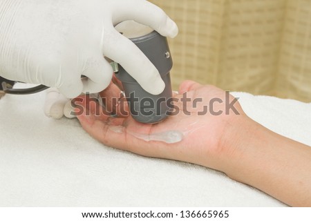 Physiotherapist is applying ultrasound therapy on the hand with ultrasound head transducer,Medical equipment use for release pain