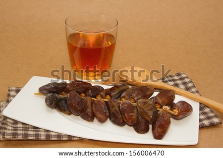 Date fruits in white plate with green tea
