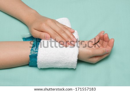 a woman applying cold pack on swollen hurting wrist after accident