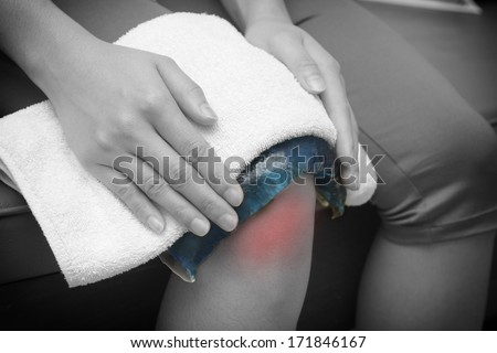 a woman applying cold pack on  swollen hurting knee after accident