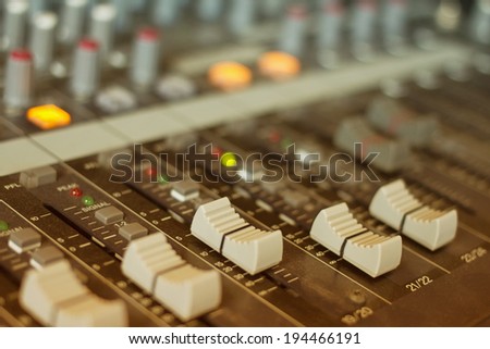 audio mixing console with faders and adjusting