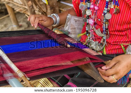 Woman working at the loom. thai national crafts. Focus on the fabric