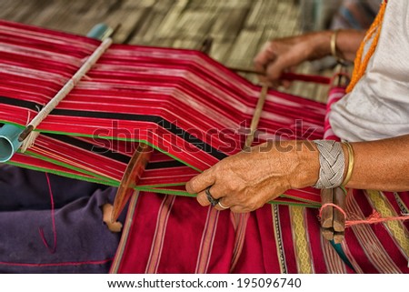 Woman working at the loom. thai national crafts. Focus on the fabric