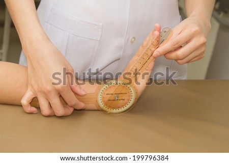 Physiotherapist measuring range of motion patients' wrist with goniometer